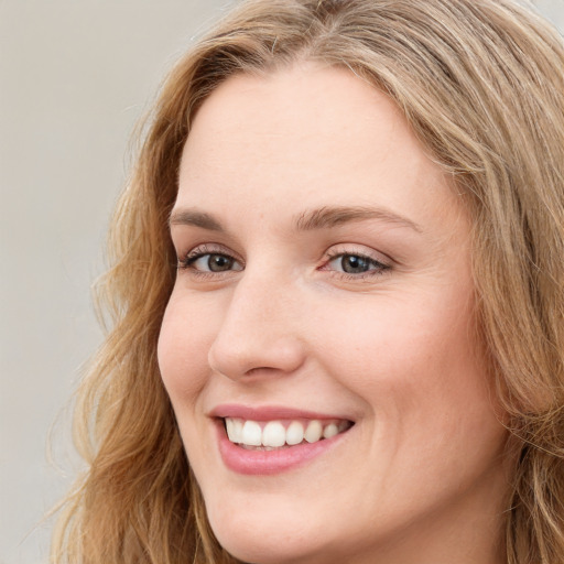 Joyful white young-adult female with long  brown hair and blue eyes