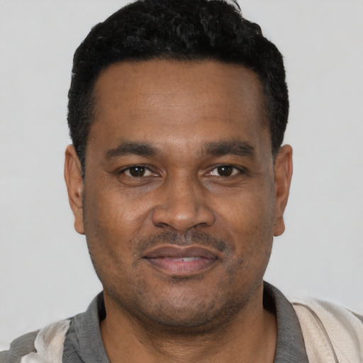 Joyful latino adult male with short  black hair and brown eyes