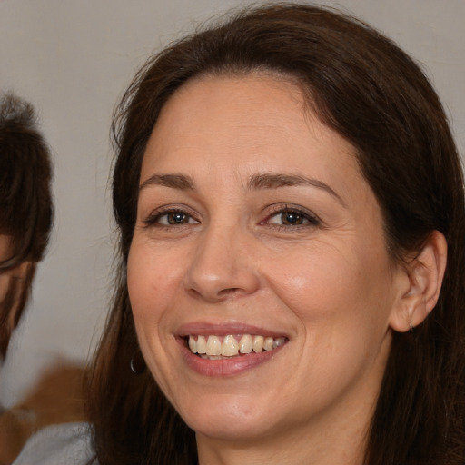 Joyful white adult female with medium  brown hair and brown eyes