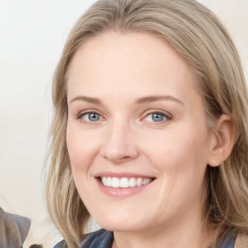 Joyful white young-adult female with long  brown hair and blue eyes