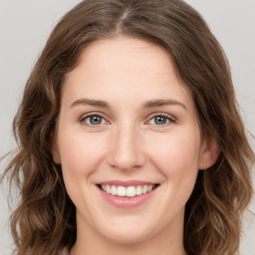 Joyful white young-adult female with medium  brown hair and green eyes