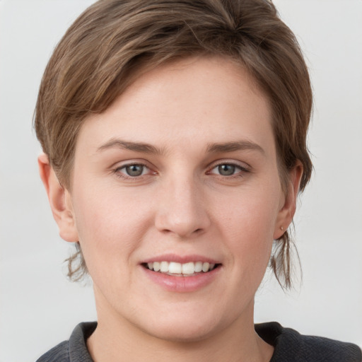 Joyful white young-adult female with short  brown hair and grey eyes