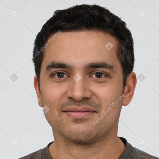 Joyful latino young-adult male with short  black hair and brown eyes