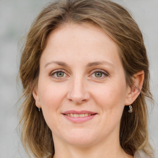 Joyful white young-adult female with medium  brown hair and green eyes