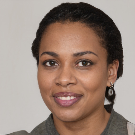 Joyful black young-adult female with medium  black hair and brown eyes