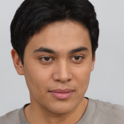 Joyful latino young-adult male with short  brown hair and brown eyes