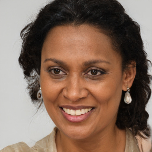 Joyful latino adult female with medium  brown hair and brown eyes