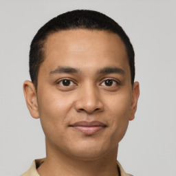 Joyful latino young-adult male with short  black hair and brown eyes