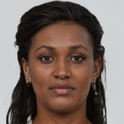 Joyful black young-adult female with long  brown hair and brown eyes