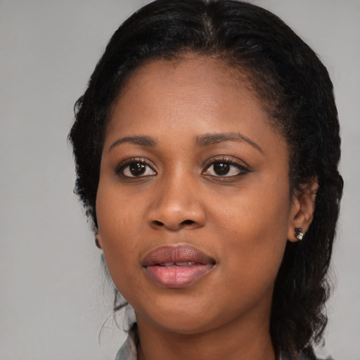 Joyful black young-adult female with long  black hair and brown eyes