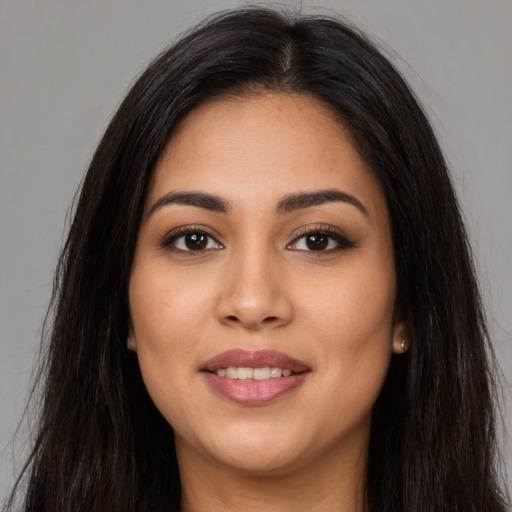 Joyful latino young-adult female with long  brown hair and brown eyes