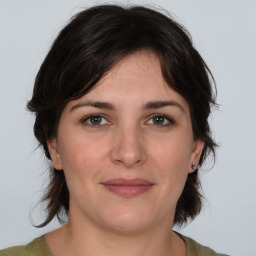 Joyful white young-adult female with medium  brown hair and green eyes