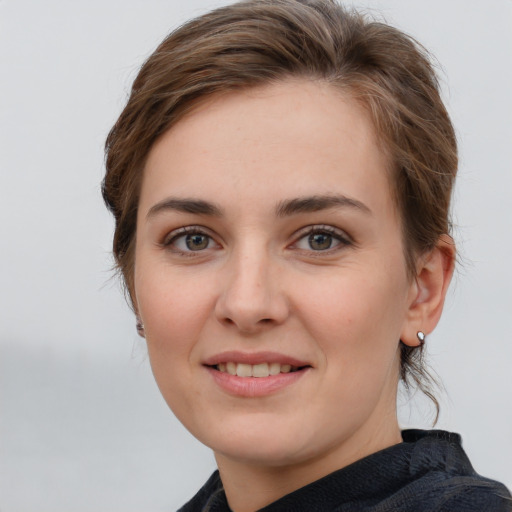 Joyful white young-adult female with medium  brown hair and grey eyes