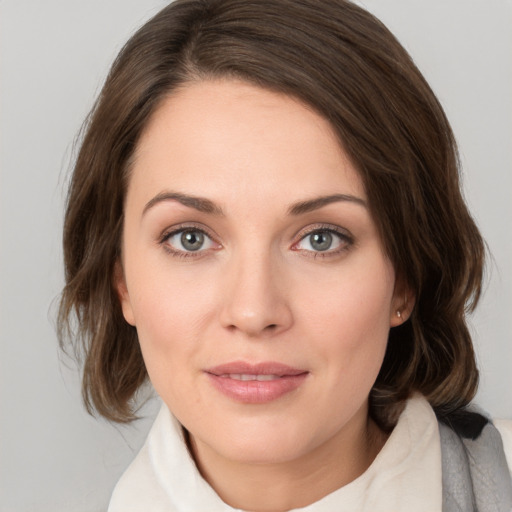 Joyful white young-adult female with medium  brown hair and green eyes