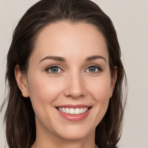 Joyful white young-adult female with long  brown hair and grey eyes