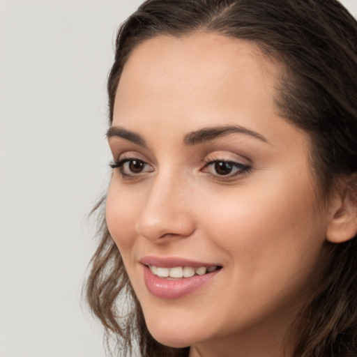 Joyful white young-adult female with long  brown hair and brown eyes