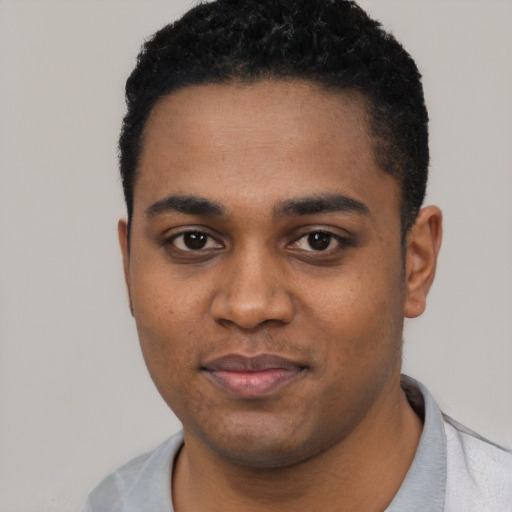 Joyful black young-adult male with short  black hair and brown eyes