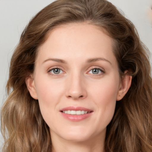 Joyful white young-adult female with long  brown hair and green eyes