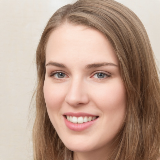 Joyful white young-adult female with long  brown hair and green eyes