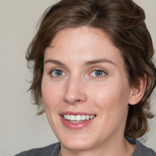 Joyful white young-adult female with medium  brown hair and blue eyes