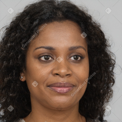 Joyful black young-adult female with long  brown hair and brown eyes