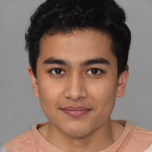 Joyful latino young-adult male with short  brown hair and brown eyes