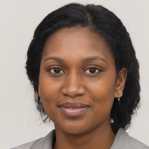 Joyful black young-adult female with long  black hair and brown eyes
