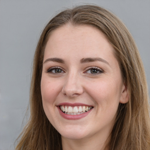 Joyful white young-adult female with long  brown hair and grey eyes