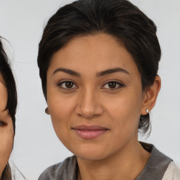 Joyful latino young-adult female with medium  brown hair and brown eyes