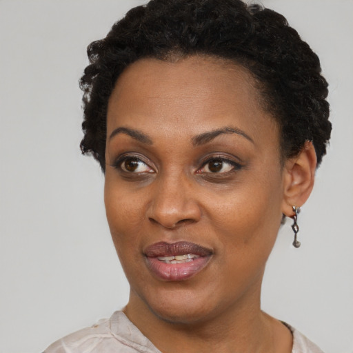 Joyful black adult female with short  black hair and brown eyes