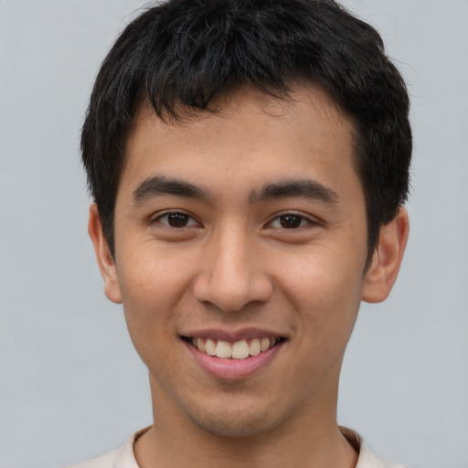 Joyful latino young-adult male with short  brown hair and brown eyes