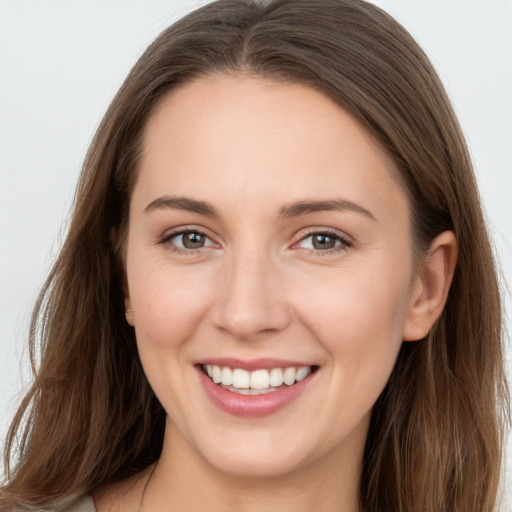 Joyful white young-adult female with long  brown hair and grey eyes