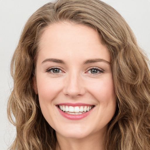 Joyful white young-adult female with long  brown hair and green eyes