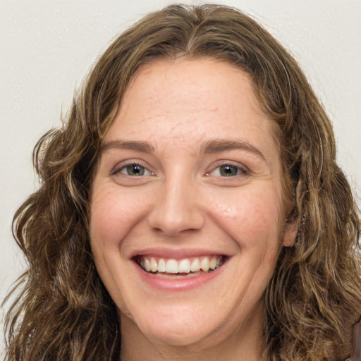 Joyful white young-adult female with long  brown hair and green eyes