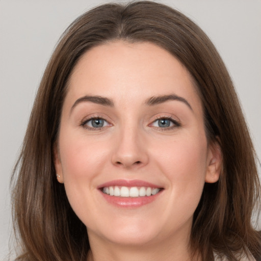 Joyful white young-adult female with long  brown hair and grey eyes