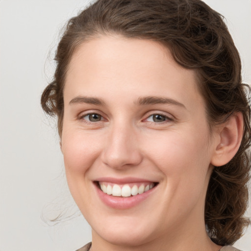 Joyful white young-adult female with medium  brown hair and green eyes