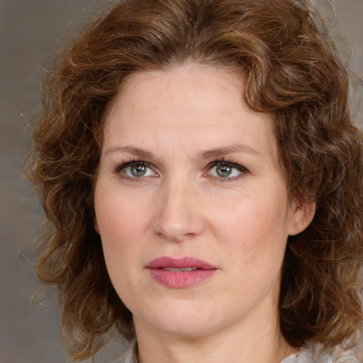 Joyful white adult female with medium  brown hair and green eyes