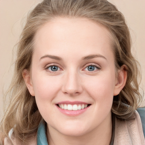 Joyful white young-adult female with long  brown hair and blue eyes