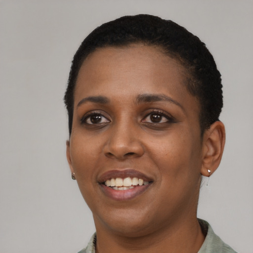 Joyful black young-adult female with short  black hair and brown eyes