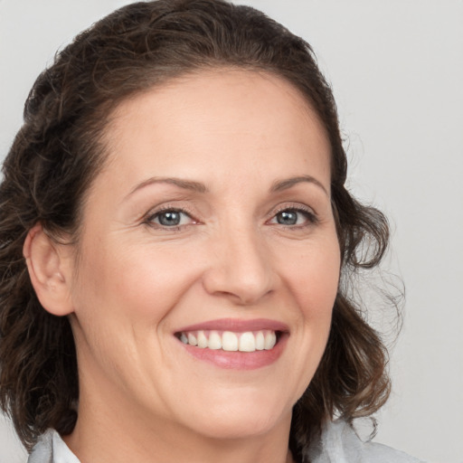 Joyful white adult female with medium  brown hair and grey eyes