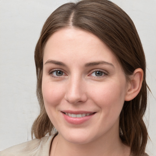 Joyful white young-adult female with medium  brown hair and grey eyes