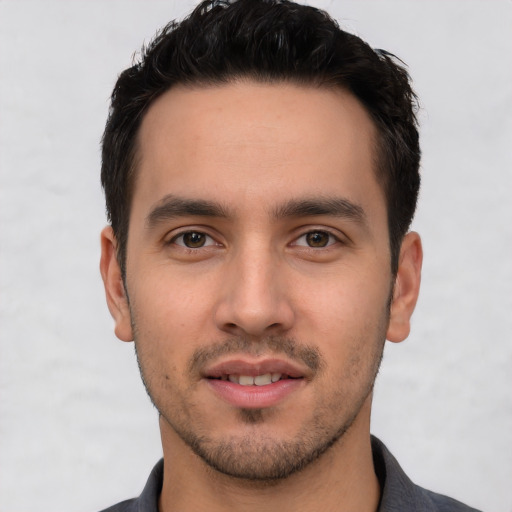 Joyful white young-adult male with short  black hair and brown eyes