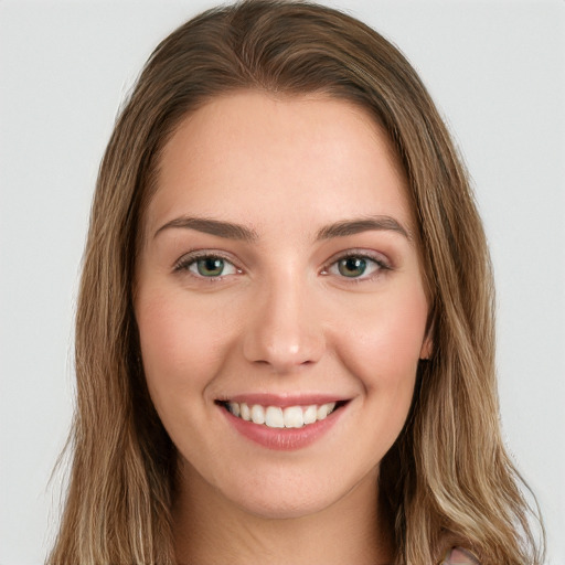 Joyful white young-adult female with long  brown hair and green eyes