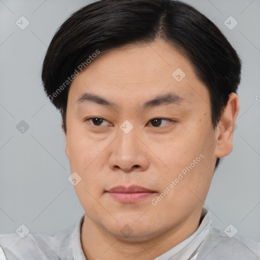 Joyful asian young-adult male with short  brown hair and brown eyes