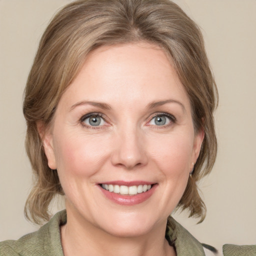 Joyful white young-adult female with medium  brown hair and green eyes