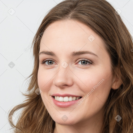 Joyful white young-adult female with long  brown hair and green eyes