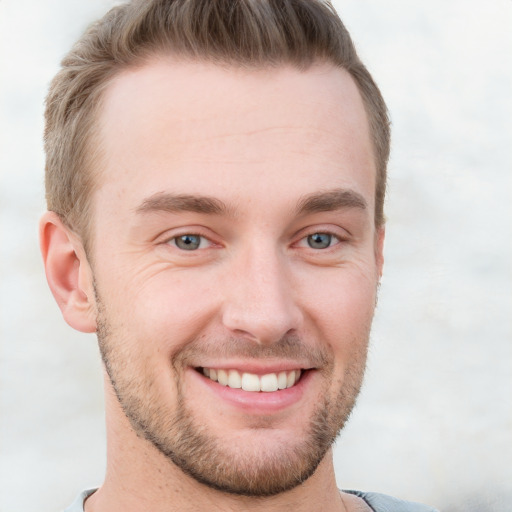 Joyful white young-adult male with short  brown hair and grey eyes