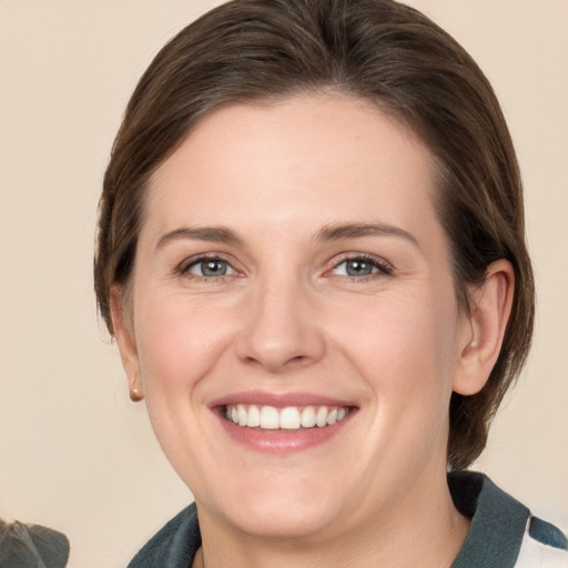 Joyful white young-adult female with medium  brown hair and grey eyes