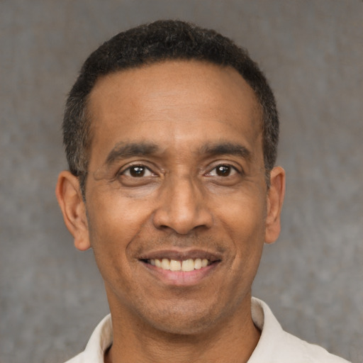Joyful latino adult male with short  black hair and brown eyes