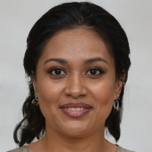 Joyful black adult female with medium  brown hair and brown eyes